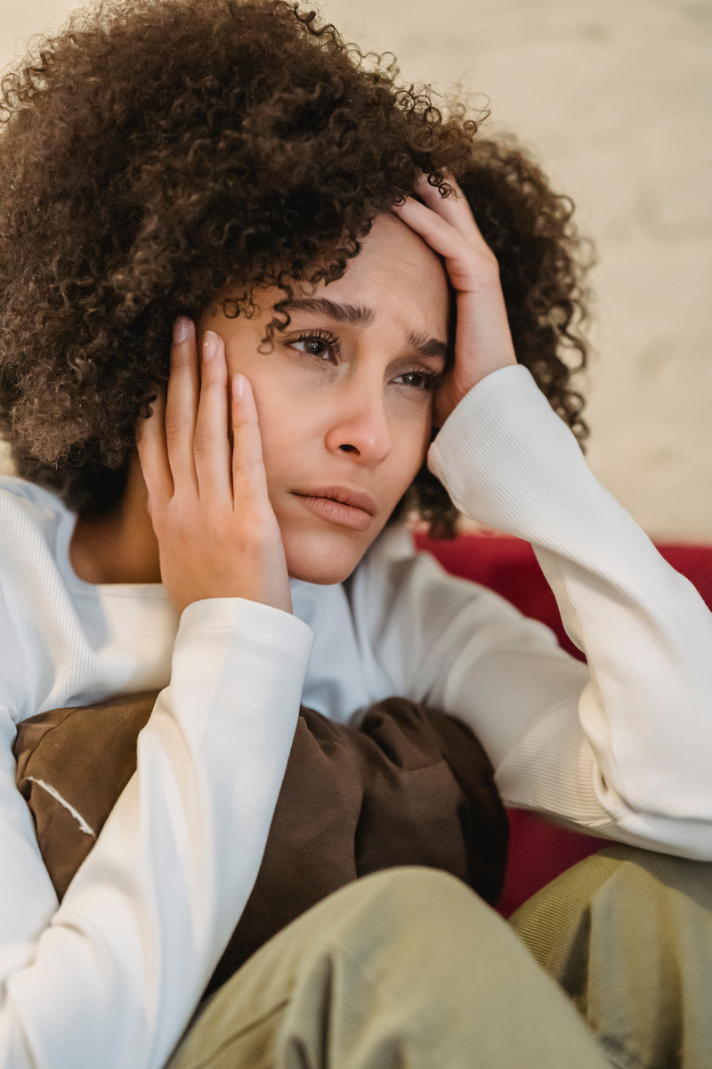 Sad black woman sitting on couch